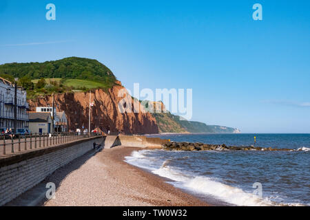 Sidmouth, Devon, Regno Unito. Graziosa cittadina sul lungomare della Jurassic Coast con spiaggia di ciottoli e rosso drammatiche scogliere di arenaria Foto Stock