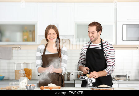 Coppia giovane preparare la pasta sul tavolo da cucina Foto Stock