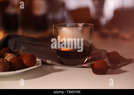 Tartufi di cioccolato e un bicchiere di vino rosso sul tavolo closeup Foto Stock