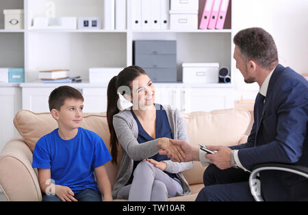 Giovane donna con figlio durante l'insegnante-madre incontro a scuola Foto Stock