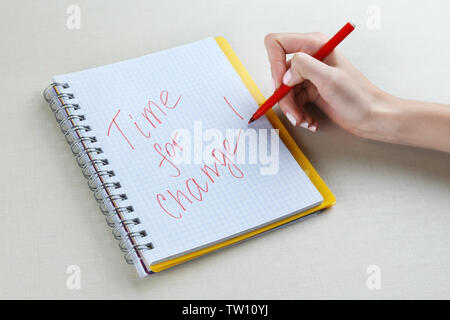 Femmina scrittura a mano la frase il tempo per cambiare in notebook Foto Stock