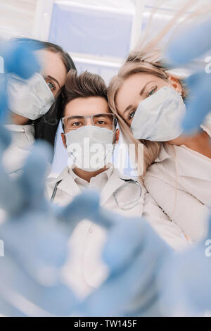 I chirurghi del Team sta eseguendo un'operazione utilizzando strumenti medicali, in una moderna sala operatoria, vista dal basso Foto Stock