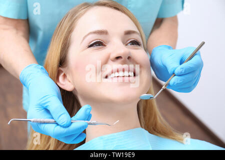 Dentista esaminando denti del paziente in clinica Foto Stock