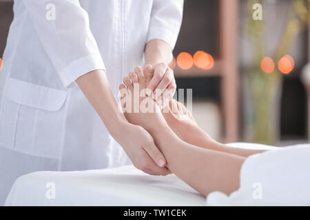 Massaggiatore femminile massaggiare i piedi femminili in spa salone Foto Stock