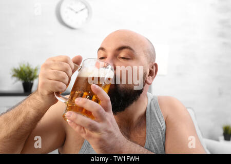 Uomo di bere birra a casa Foto Stock