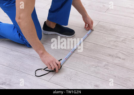 Uomo di installare nuovi in legno pavimenti in laminato Foto Stock