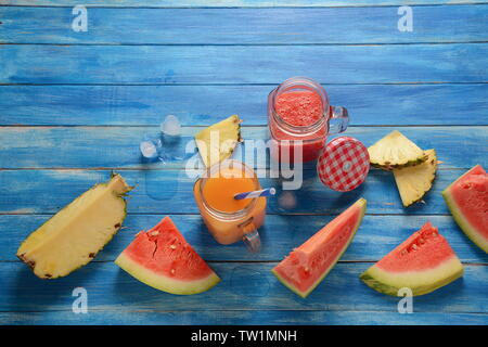 Anguria fresca e ananas cocktail in bicchieri su un blu in legno rustico sfondo.estate freddo anguria e ananas frullato. Foto Stock