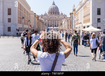 Roma, Italia - 27 Aprile 2019: giovane donna fotografie la Basilica di San Pietro, Roma, Italia. Foto Stock
