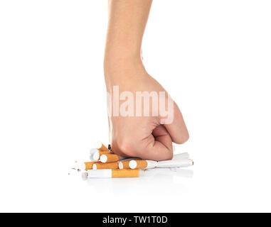 Mano umana la frantumazione di sigarette su sfondo bianco Foto Stock