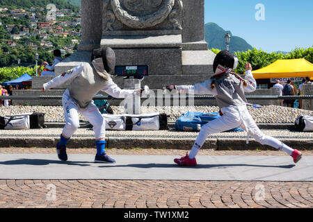 CERNOBBIO, Italia - 16 giugno 2019: Kid schermitori scherma e mettere in pratica con la spada durante una festa dello sport Foto Stock