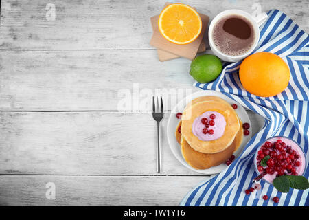 Gustosi pancake con yogurt e frutta sul tavolo Foto Stock