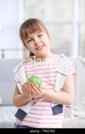 Felice schoolgirl in piedi con Apple da casa Foto Stock