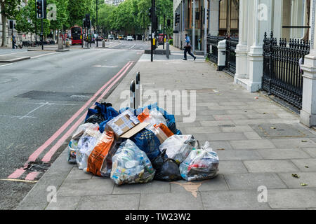 London, Regno Unito - 30 Maggio 2019: i rifiuti ammucchiati sul lato di una strada di Londra. Foto Stock