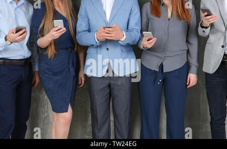 I giovani in abiti aziendali utilizzando gli smartphone grigio Sfondo testurizzata Foto Stock