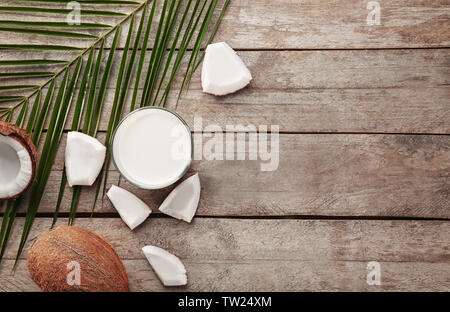 Composizione con gustosi piatti di latte di cocco su sfondo di legno Foto Stock