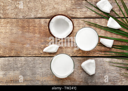 Composizione con gustosi piatti di latte di cocco su sfondo di legno Foto Stock