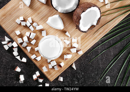 Composizione con fresco latte di cocco sul tavolo scuro Foto Stock