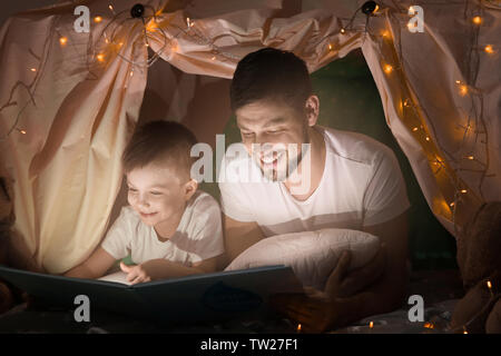 Padre e figlio libro di lettura nel Tugurio a casa Foto Stock