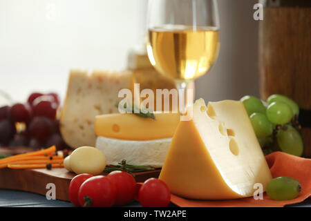Tavola di legno con una varietà di formaggio su tavola Foto Stock