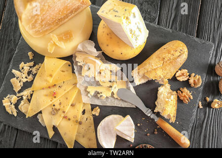 Piastra di ardesia con varietà di formaggio sulla tabella Foto Stock