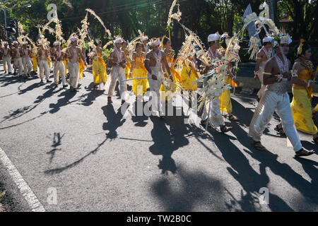 DENPASAR/BALI-Giugno 15 2019: Sampian ballerino, indossando giallo e bianco costume tradizionale, camminando per eseguire a Bali Arts Festival 2019. Essi utilizzano palm Foto Stock