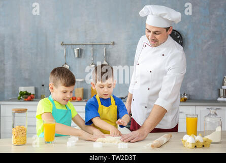 Uomo e due ragazzi la cucina insieme in cucina Foto Stock