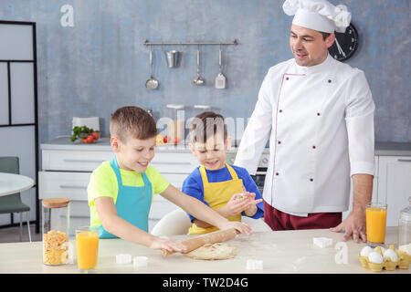 Uomo e due ragazzi la cucina insieme in cucina Foto Stock