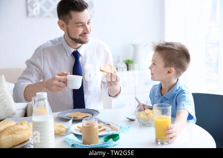 Papà e figlio avente il pranzo a casa Foto Stock