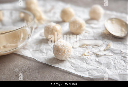 Gustose caramelle in scaglie di cocco su sfondo grigio Foto Stock