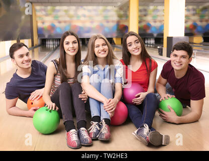 Amici divertendosi in bowling club Foto Stock