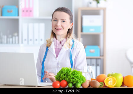 Giovani femmine nutrizionista con laptop lavorando nel suo ufficio Foto Stock