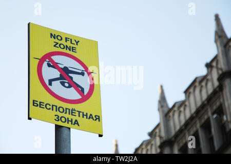Segno che vieta drone battenti con iscrizione "no fly zone" in inglese e russo Foto Stock