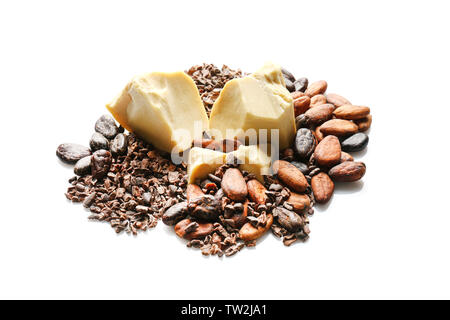 Pila di fave di cacao, burro e pennini su sfondo bianco Foto Stock