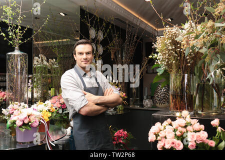 Bello fioraio nel negozio di fiori Foto Stock