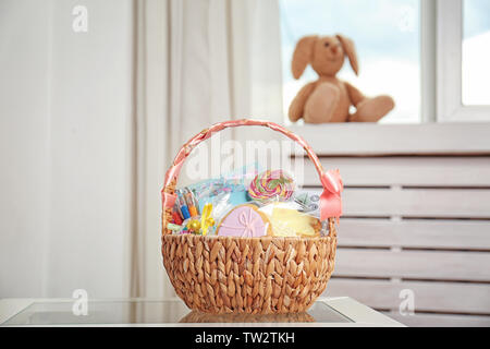 Cesto di pasqua con dolci e articoli di cancelleria su sfondo chiaro Foto Stock