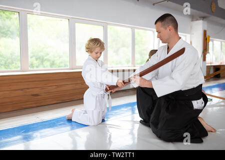 Ragazzo tenendo jo. Biondo e carino piccolo ragazzo sentimento grave tenendo jo dal trainer Foto Stock