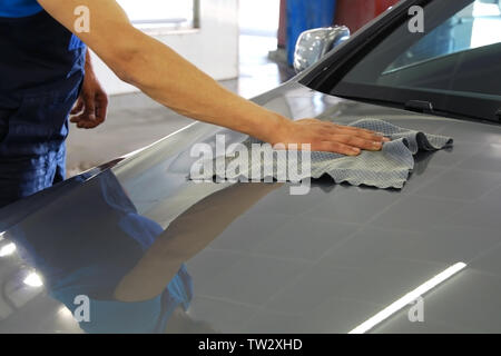 Rondella auto uomo panni e lucidi per cofano auto dopo il lavaggio con speciali rag Foto Stock