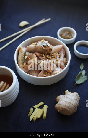 Ali di pollo marinato con lo zenzero, aglio, la senape, la salsa di soia e il miele. Cibo asiatico. Foto Stock