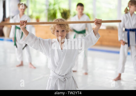 Ragazzo sentirsi soddisfatto. Carino dark-eyed boy sensazione eccitati e soddisfatti dopo la pratica di aikido Foto Stock