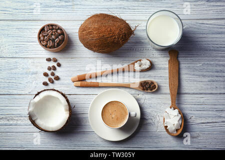 Cup con bevande e ingredienti per il caffè di noce di cocco sul tavolo di legno Foto Stock