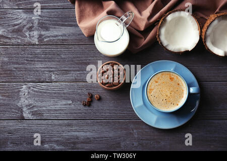 Cup con bevande e ingredienti per il caffè di noce di cocco sul tavolo di legno Foto Stock