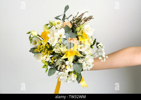 Donna che mantiene bouquet con fresia fiori su sfondo bianco Foto Stock