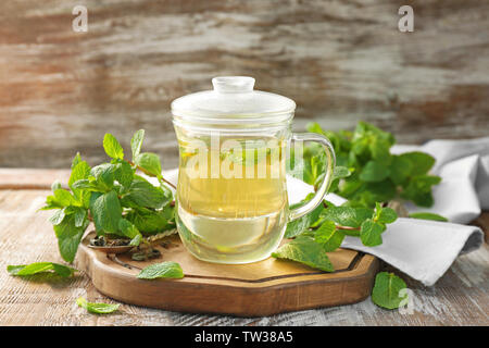 Tazza di caldo gustoso tè con melissa sul tavolo di legno Foto Stock