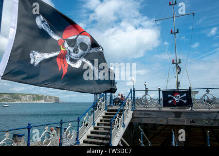 Un Teschio e Ossa Croce pirate sventola sul molo a Swanage, Dorset, Regno Unito Foto Stock