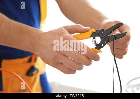 Elettricista fili di taglio in ambienti chiusi, primo piano Foto Stock