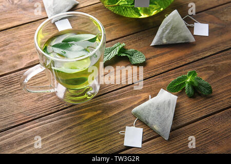 Composizione con teabags, foglie di menta e la coppa sul tavolo di legno. La perdita di peso concept Foto Stock