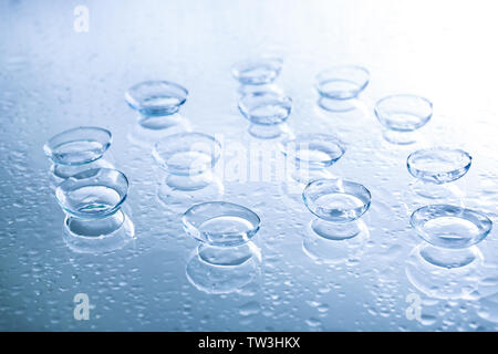 Le lenti a contatto e gocce di acqua sul colore di sfondo Foto Stock