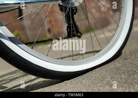 Vista ingrandita del piatto di bicicletta pneumatico sul marciapiede Foto Stock