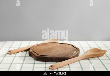 Tavola di legno e gli utensili sulla tovaglia Foto Stock