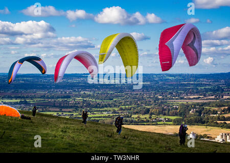 Gruppo di 4 parapendio con paracadute colorato preparando per prendere il via al Westbury, Wiltshire, Regno Unito il 6 ottobre 2012 Foto Stock